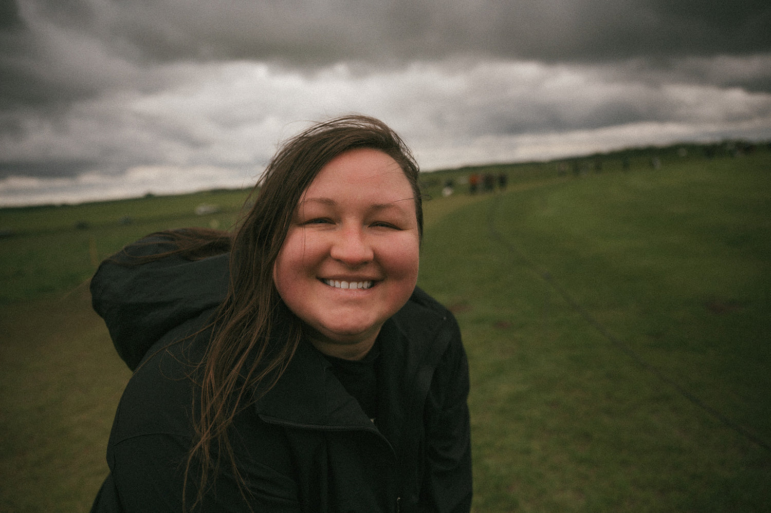 girl smiling at camera on a cloudy day